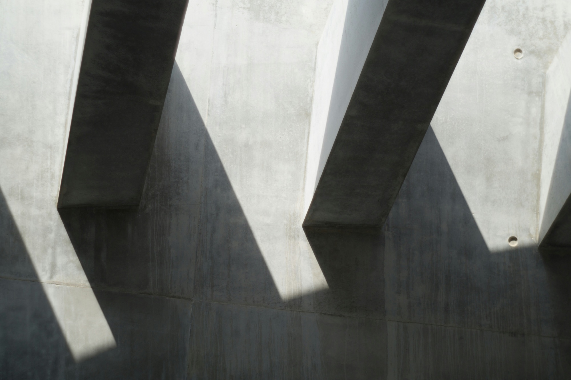 Hard light and shadow across a concrete facade.